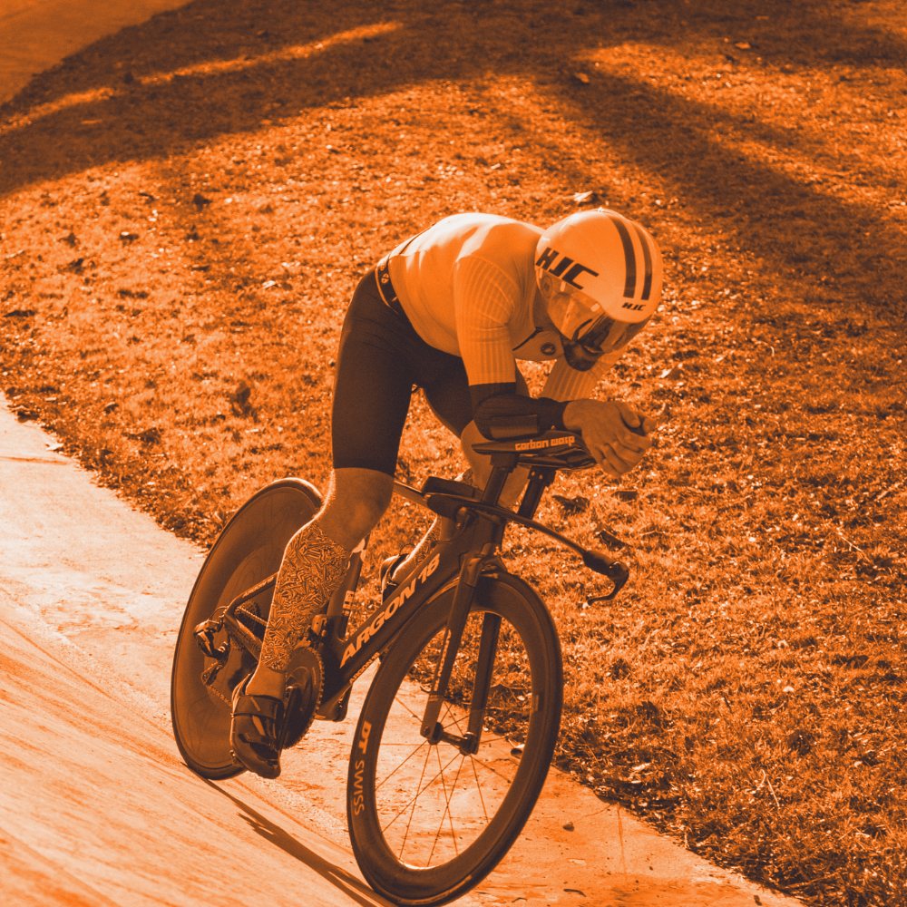 Triathlète en position aérodynamique dans le virage relevé du vélodrome de Foix